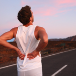 A person jogging on a road in Vancouver experiencing sciatica symptoms.