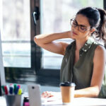 person experiencing neck pain at their office desk in vancouver bc
